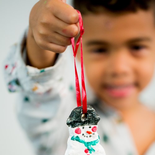 a child with a snowman ornament